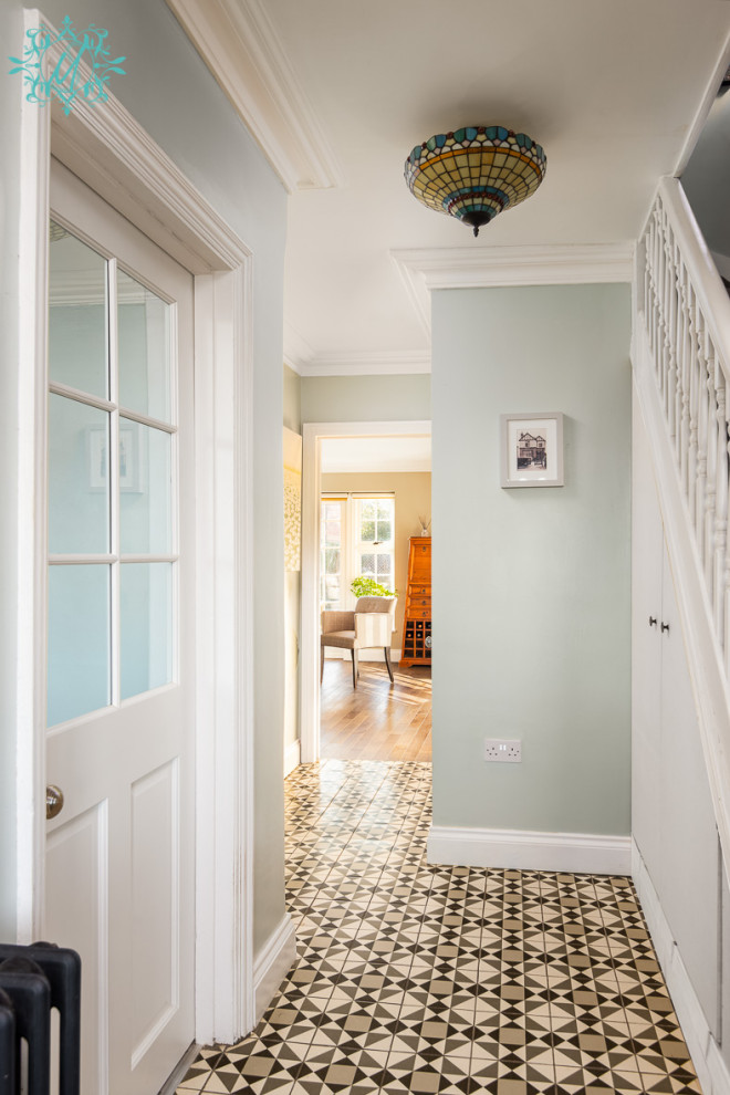 Idee per un corridoio di medie dimensioni con pareti verdi, pavimento con piastrelle in ceramica, una porta singola, una porta gialla e pavimento grigio