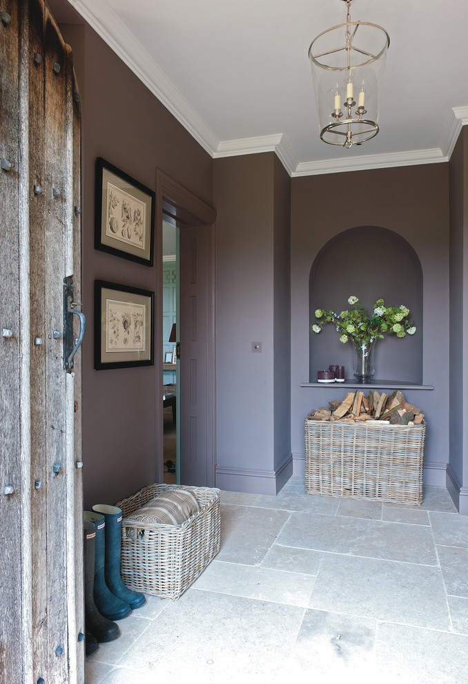This is an example of a large rural entrance in Gloucestershire with purple walls and limestone flooring.