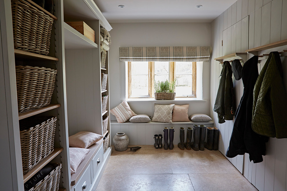 Farmhouse boot room in Gloucestershire with grey walls and beige floors.