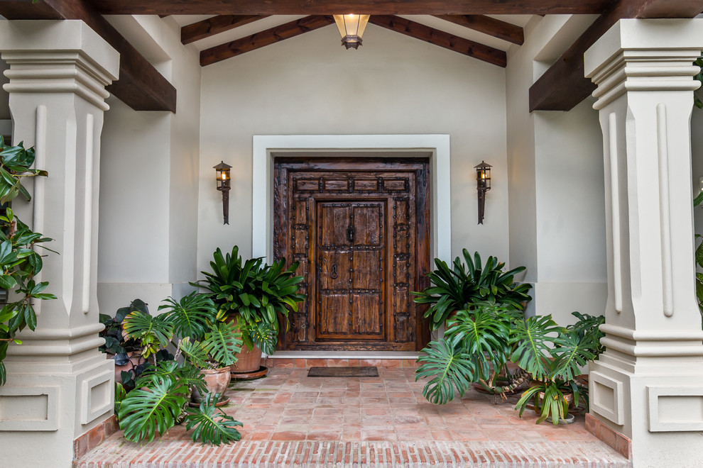 Imagen de puerta principal clásica grande con puerta de madera en tonos medios