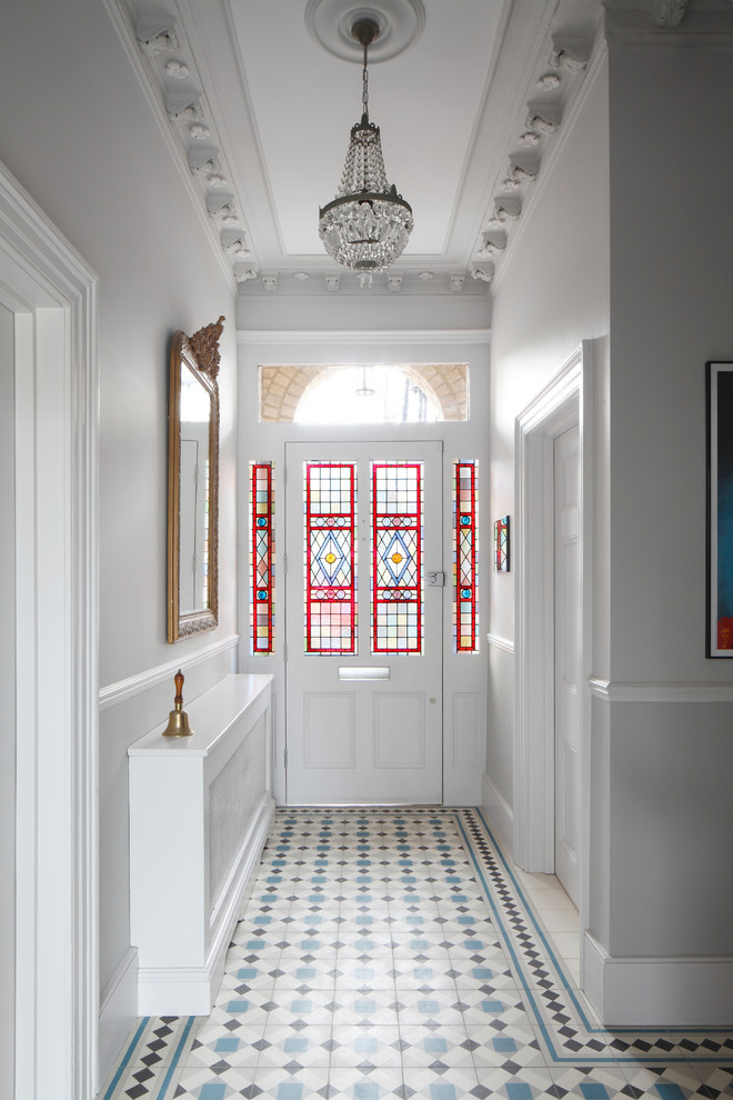 Esempio di un grande corridoio chic con pareti bianche, pavimento con piastrelle in ceramica, una porta singola, pavimento multicolore, una porta in vetro e soffitto a cassettoni