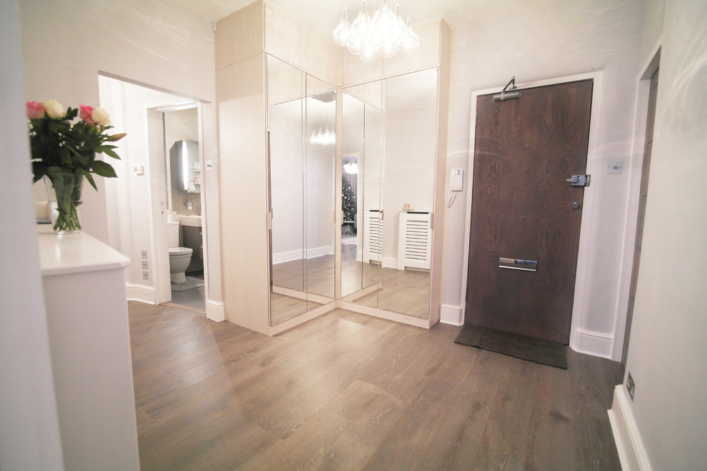 Photo of a medium sized contemporary hallway in London with a single front door and a dark wood front door.