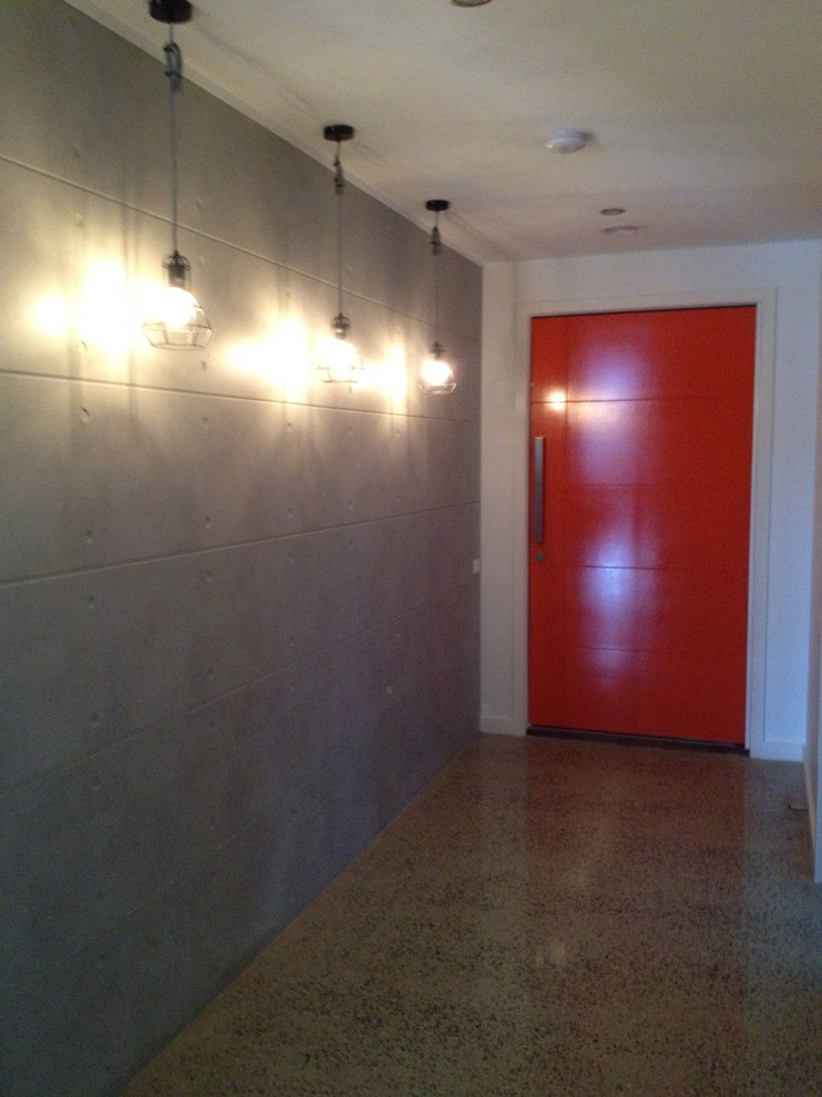 Medium sized urban entrance in Other with grey walls, concrete flooring, a single front door, grey floors and a red front door.