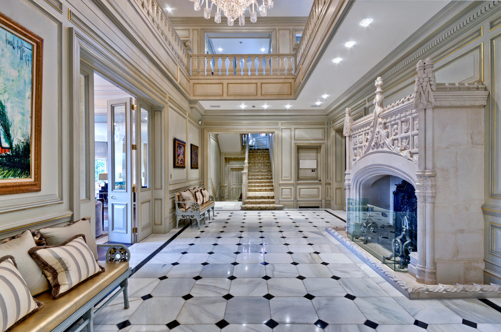 Exemple d'un très grand hall d'entrée chic avec un mur gris et un sol en marbre.