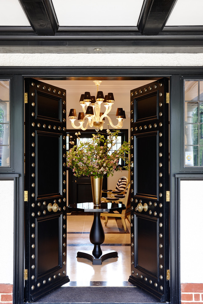 This is an example of a traditional front door in London with white walls, a double front door and a black front door.