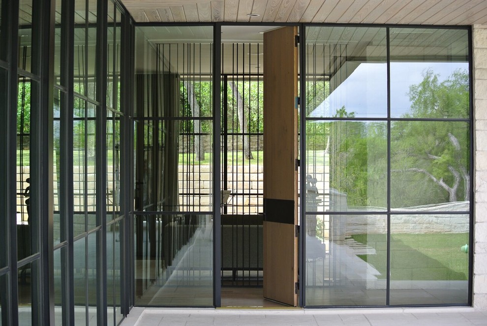 Ejemplo de puerta principal moderna con puerta simple y puerta de madera clara