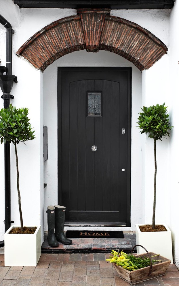 This is an example of a contemporary front door in London with a single front door and a black front door.