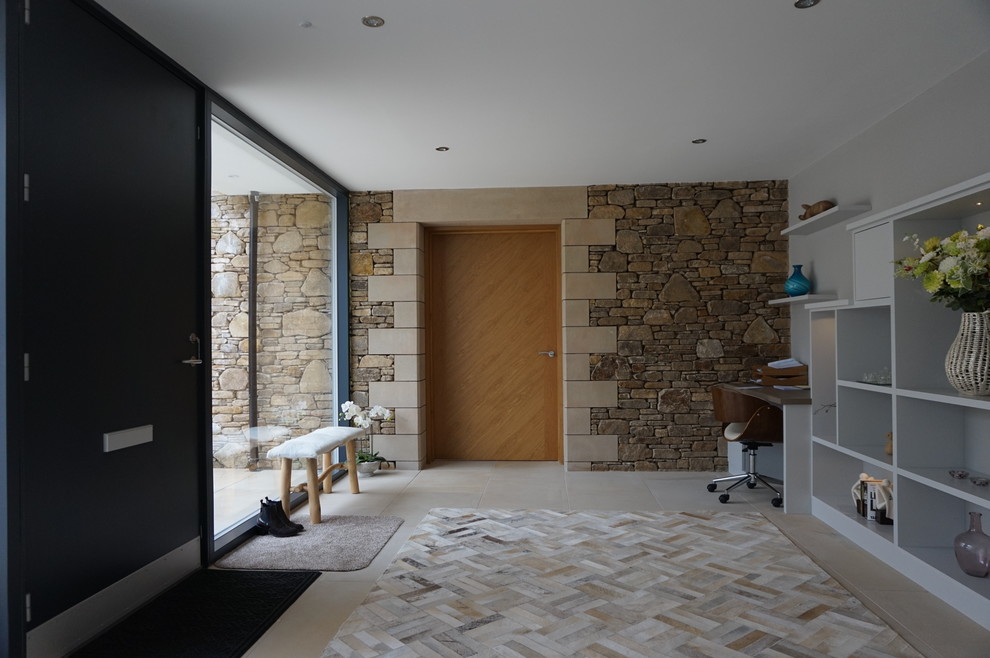 Immagine di un grande ingresso design con pavimento in pietra calcarea, una porta singola, una porta grigia, pavimento beige e pareti beige