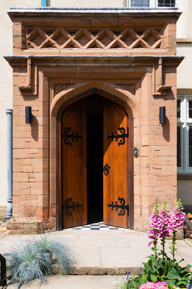 Foto di una porta d'ingresso tradizionale con una porta a due ante e una porta in legno bruno
