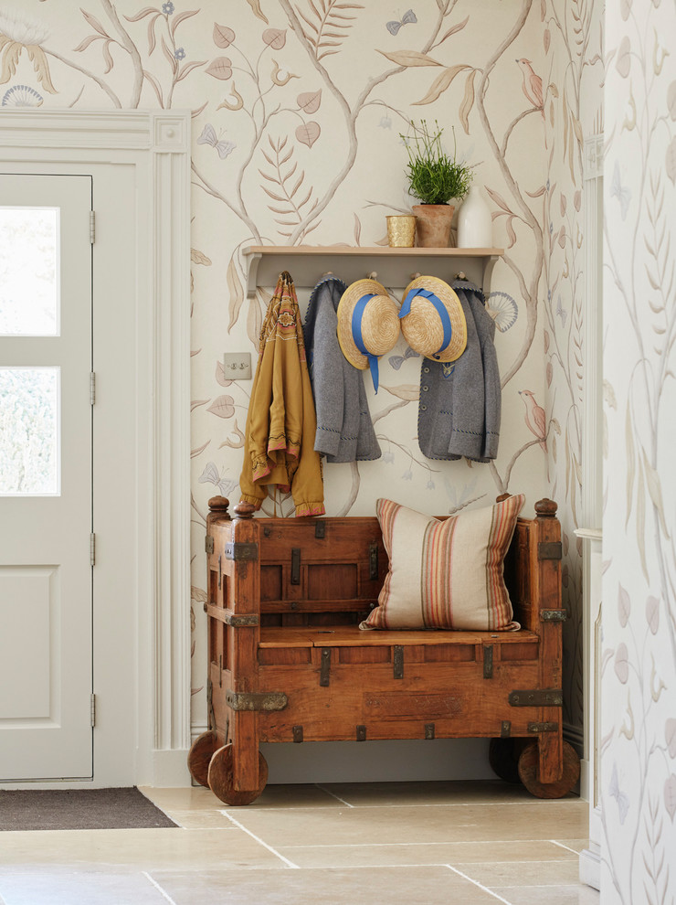 Immagine di un ingresso country con pareti beige, una porta bianca e pavimento beige