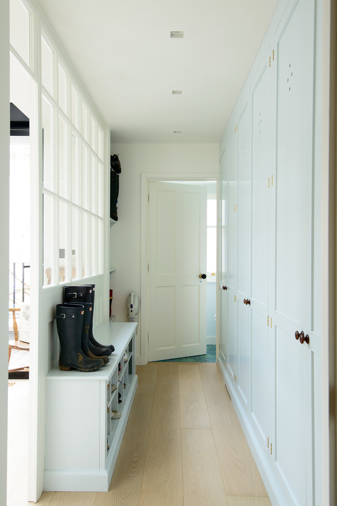Small classic entrance in London with light hardwood flooring and white walls.