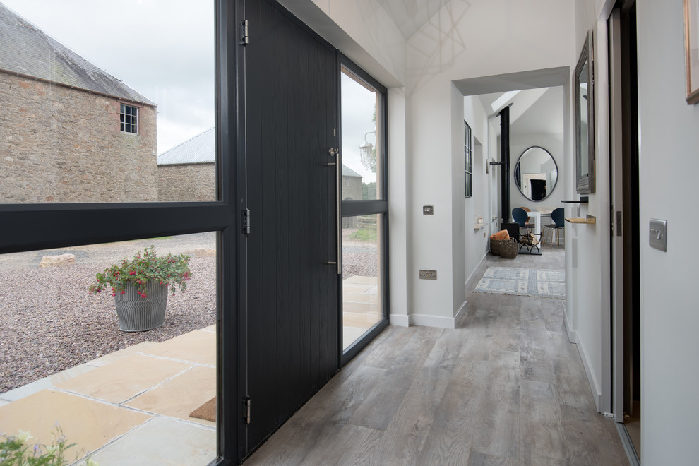 This is an example of a medium sized contemporary hallway in Other with grey walls, laminate floors, a double front door, a black front door and grey floors.