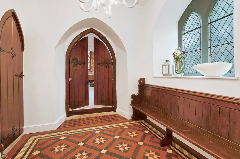 Aménagement d'une porte d'entrée classique de taille moyenne avec un mur blanc, sol en béton ciré, une porte double, une porte en bois foncé et un sol multicolore.