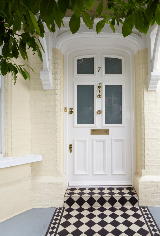 Modelo de puerta principal tradicional con paredes amarillas, puerta simple y puerta blanca