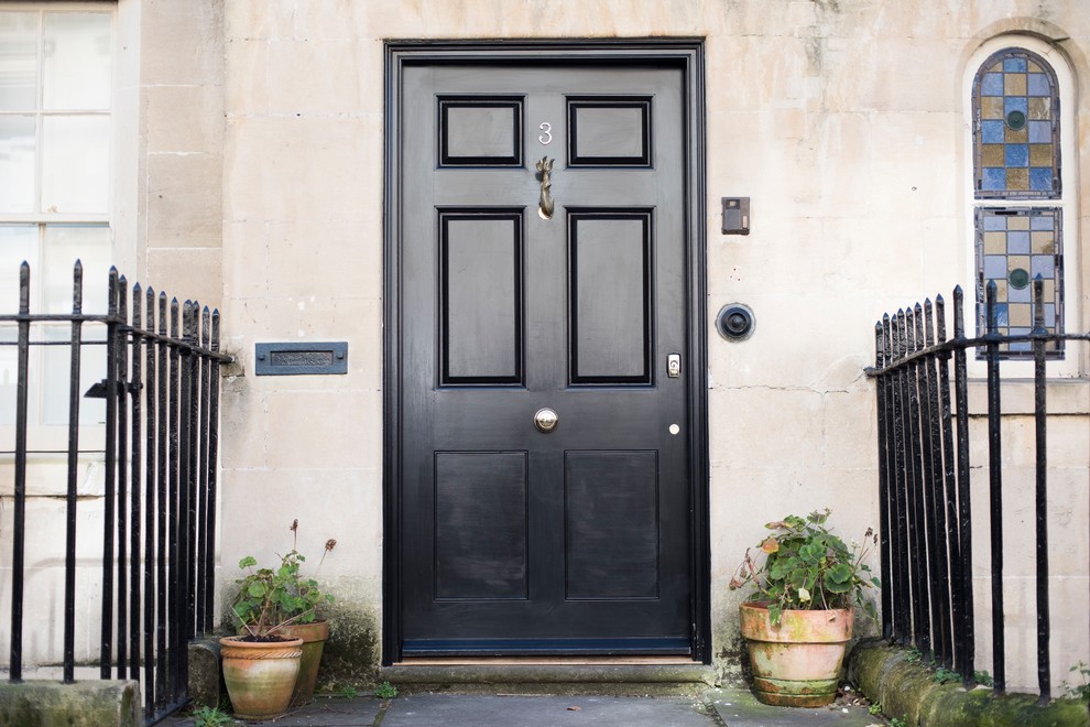 Diseño de puerta principal tradicional de tamaño medio con paredes beige, puerta simple y puerta negra