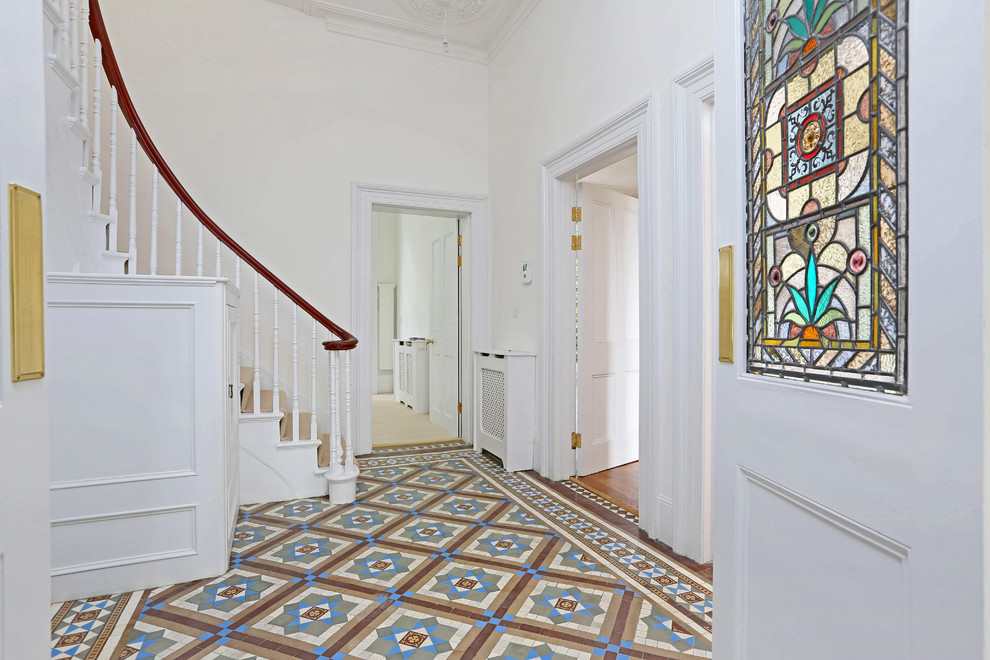 Mid-sized elegant multicolored floor entryway photo in London with white walls and a white front door