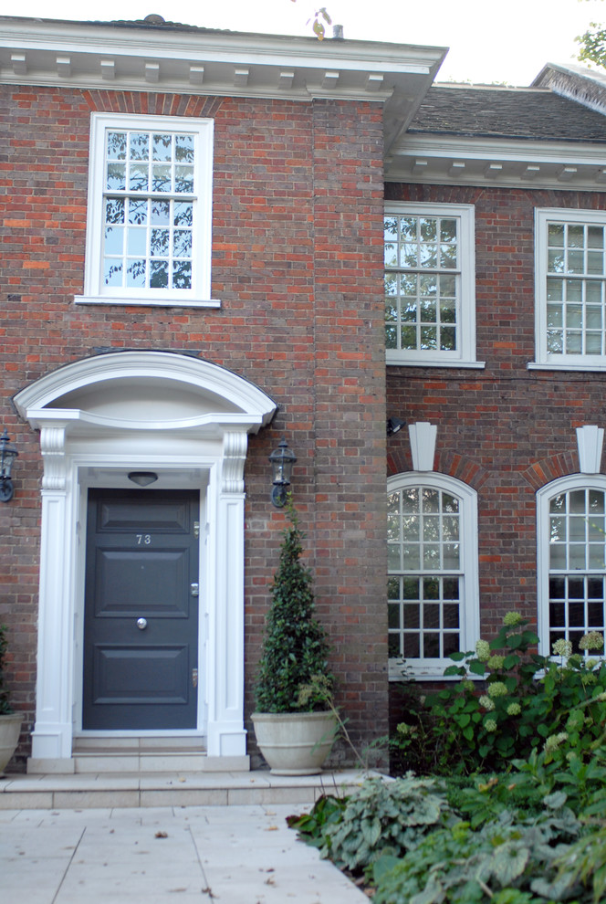 ロンドンにある高級な広いヴィクトリアン調のおしゃれな玄関ドア (ライムストーンの床、グレーのドア) の写真