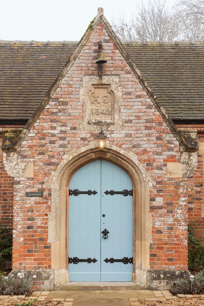 Foto på en lantlig entré, med en dubbeldörr och en blå dörr