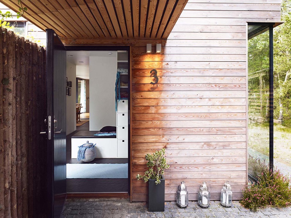 Idée de décoration pour une petite porte d'entrée chalet avec un sol en carrelage de céramique, une porte simple et une porte noire.
