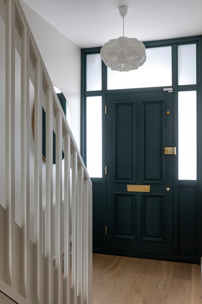 Exemple d'une porte d'entrée tendance de taille moyenne avec un mur blanc, parquet clair, une porte simple, une porte bleue et un sol marron.