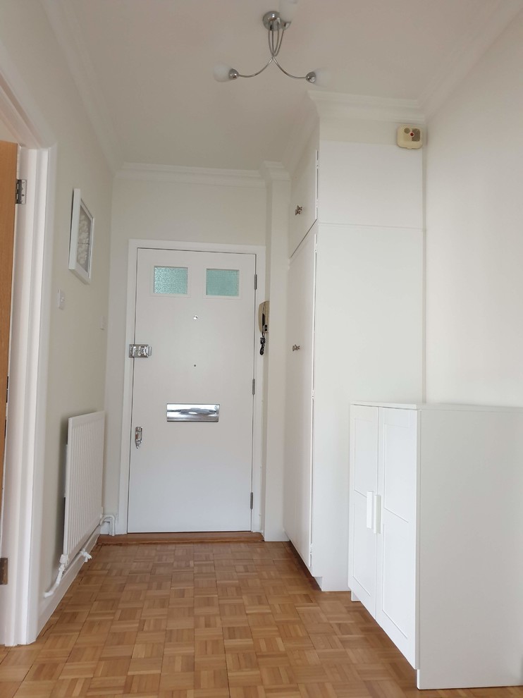 Großer Klassischer Eingang mit Korridor, gelber Wandfarbe, hellem Holzboden, Einzeltür, weißer Haustür, braunem Boden und eingelassener Decke in London