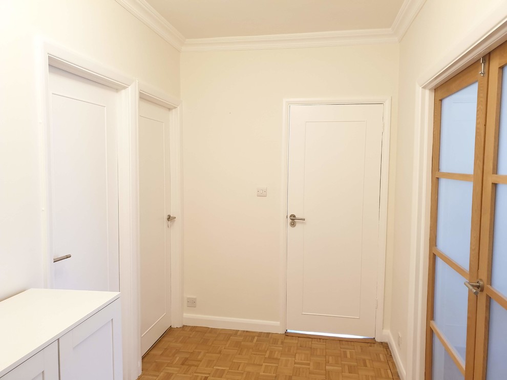 Großer Klassischer Eingang mit Korridor, gelber Wandfarbe, hellem Holzboden, Einzeltür, weißer Haustür, braunem Boden und eingelassener Decke in London