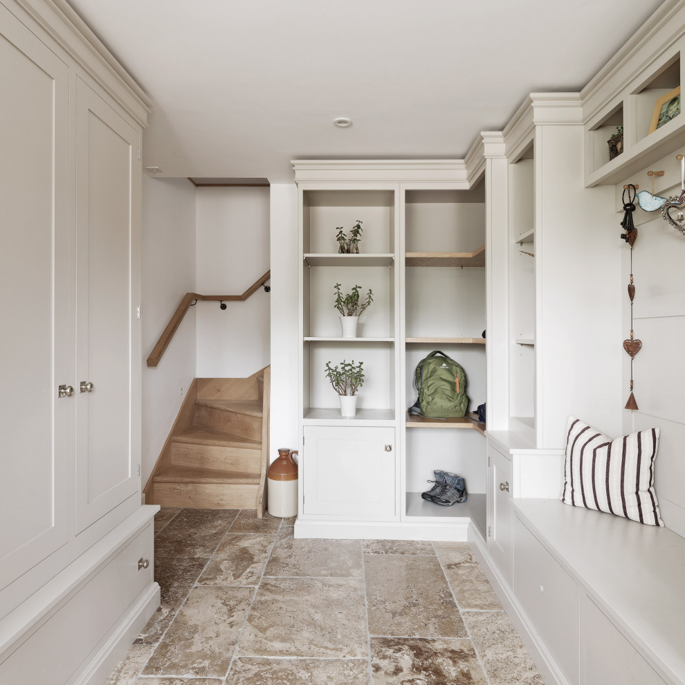 Inspiration pour une entrée traditionnelle de taille moyenne avec un vestiaire, un mur blanc et un sol gris.