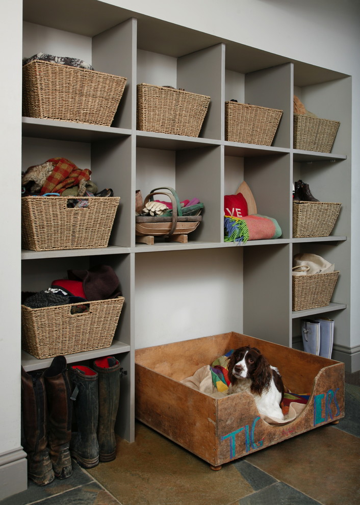 Farmhouse terra-cotta tile mudroom photo in London with white walls