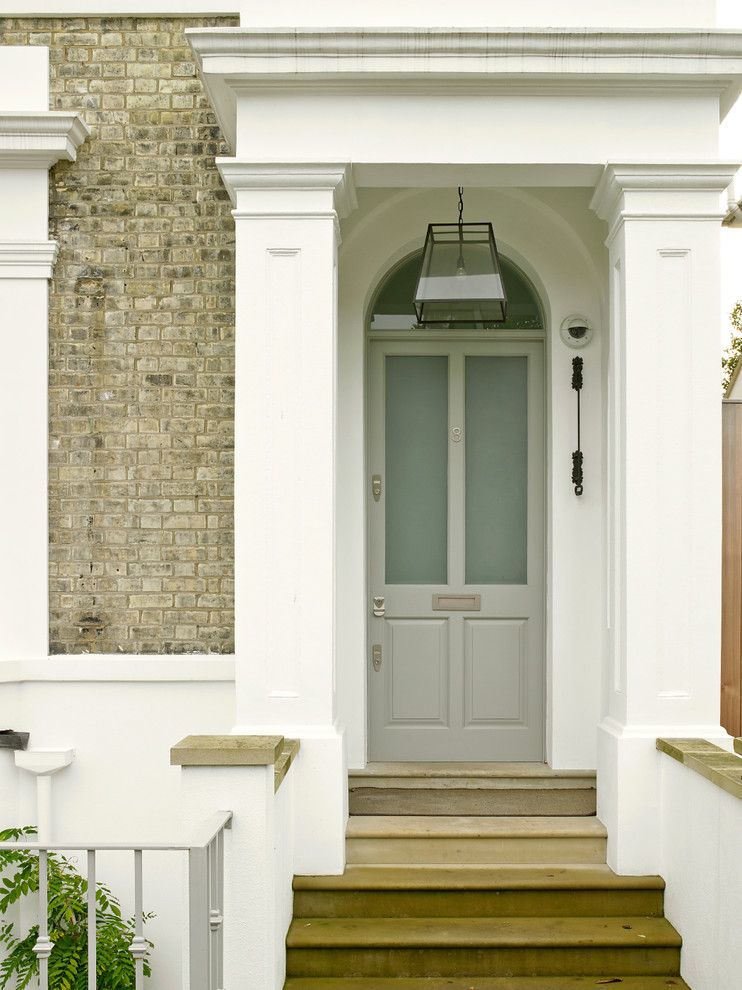 Medium sized victorian porch in London with a single front door, a grey front door and brown walls.