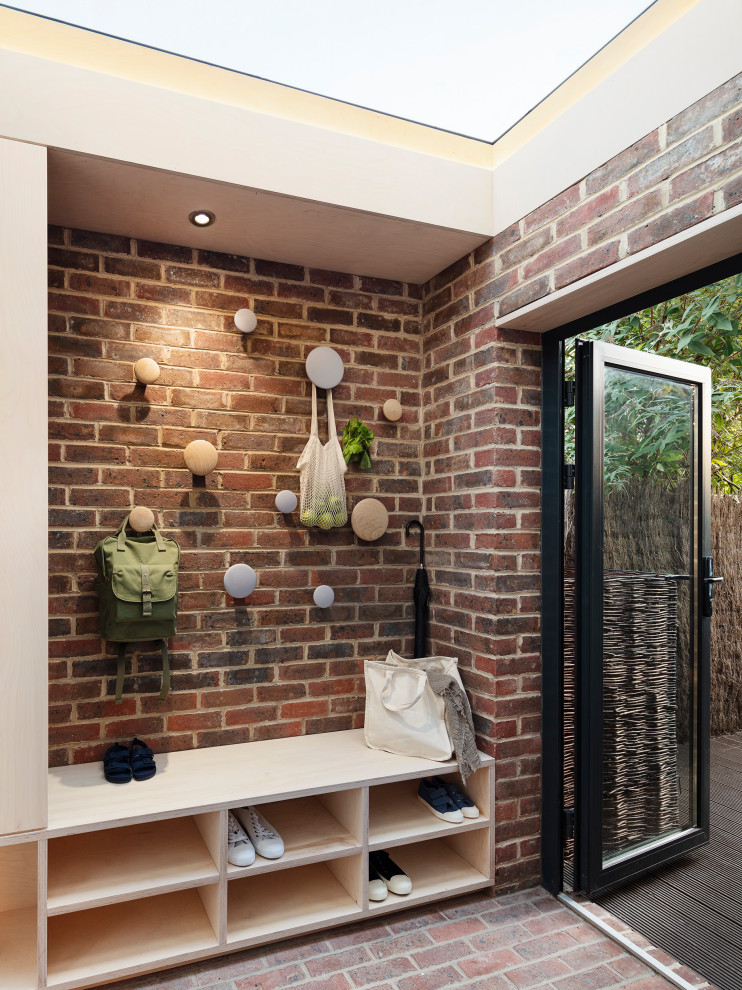 Cette image montre un petit hall d'entrée design avec un sol en brique, une porte simple, une porte grise, un plafond en bois et un mur en parement de brique.