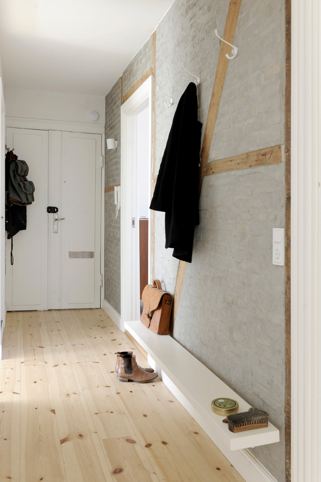 Bild på en mellanstor minimalistisk entré, med grå väggar och ljust trägolv