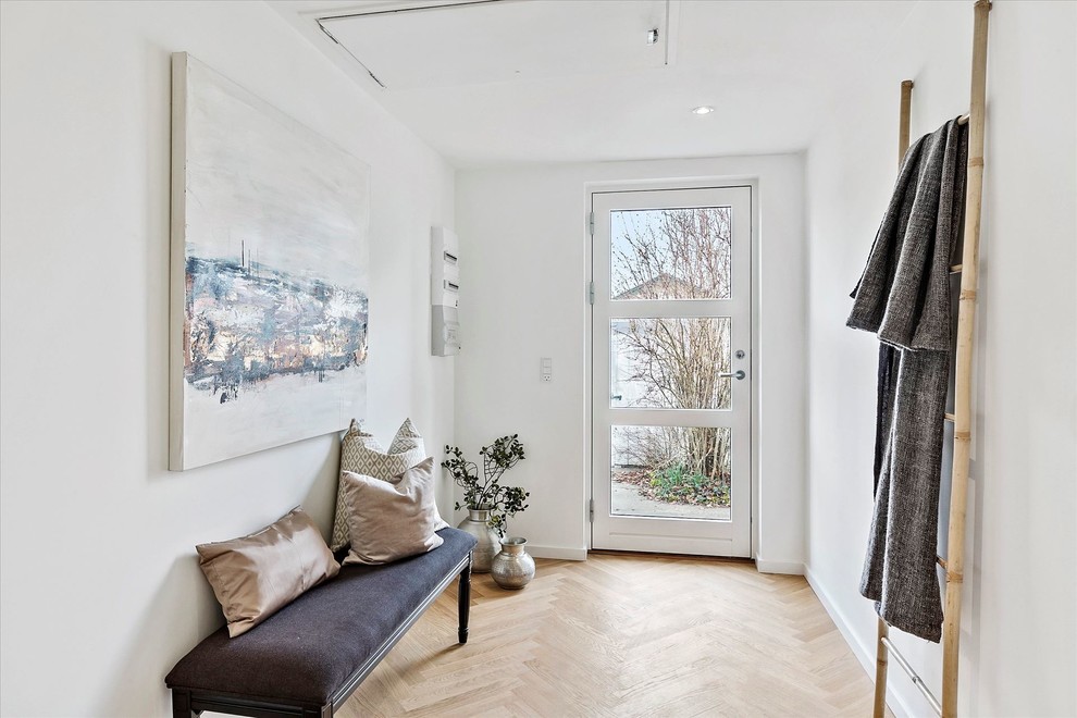 Idee per un ingresso scandinavo con pareti bianche, parquet chiaro, una porta singola, una porta bianca e pavimento beige