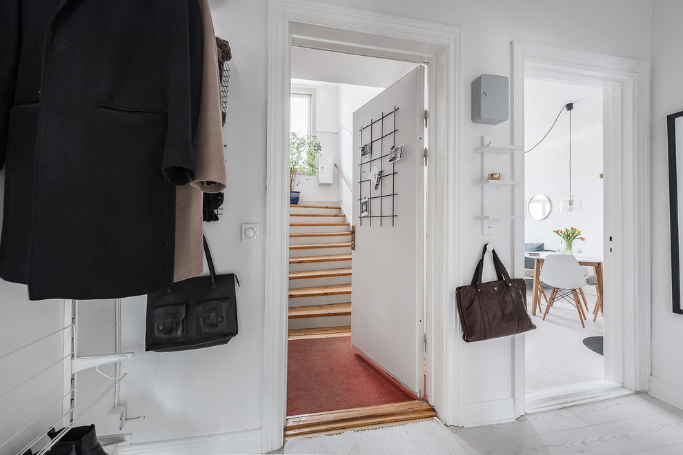 Inspiration for a small scandinavian laminate floor and white floor entryway remodel in Stockholm with white walls