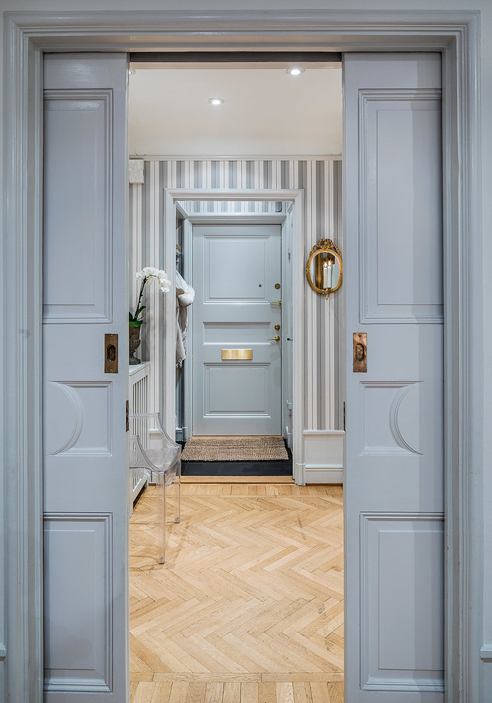 Design ideas for a large classic entrance in Stockholm with blue walls and light hardwood flooring.