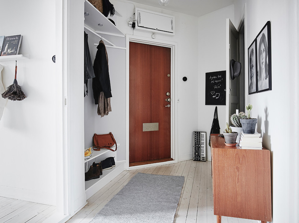 Пример оригинального дизайна: тамбур в скандинавском стиле с белыми стенами, деревянным полом, одностворчатой входной дверью, белым полом и входной дверью из дерева среднего тона