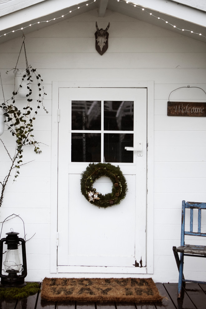 Modelo de puerta principal romántica pequeña con paredes blancas, puerta simple y puerta blanca