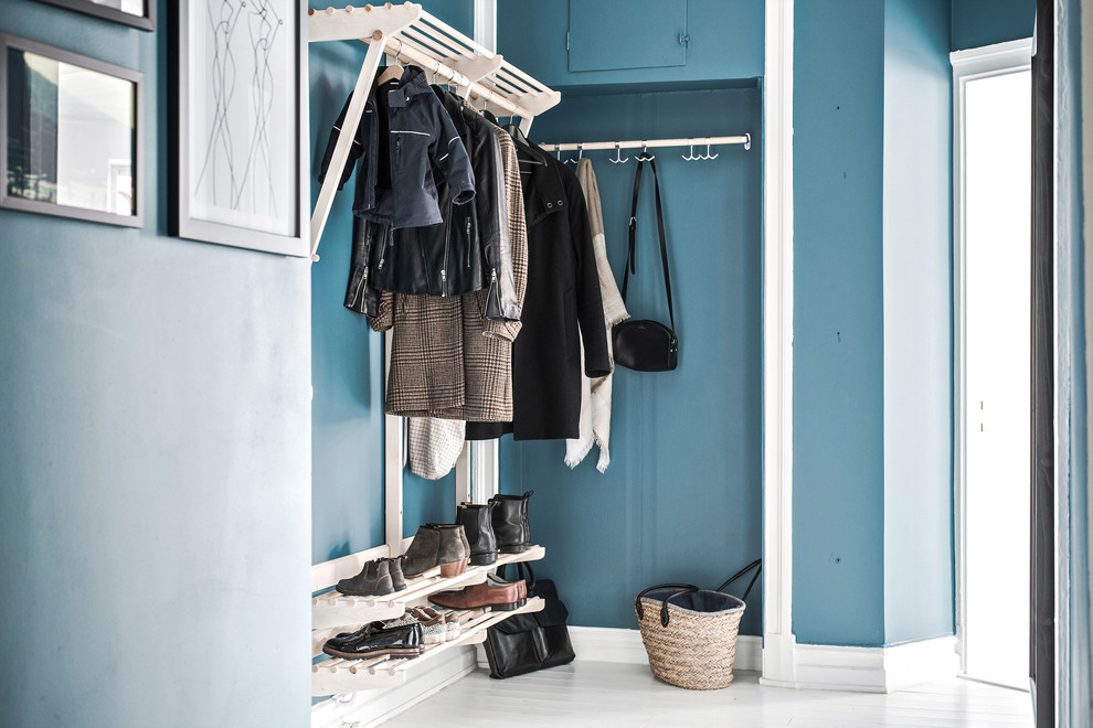 На фото: тамбур среднего размера в скандинавском стиле с синими стенами, деревянным полом и белым полом с