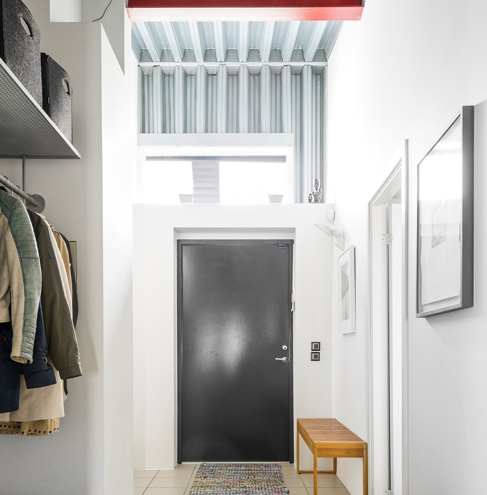 Urban beige floor entryway photo in Malmo with white walls and a black front door