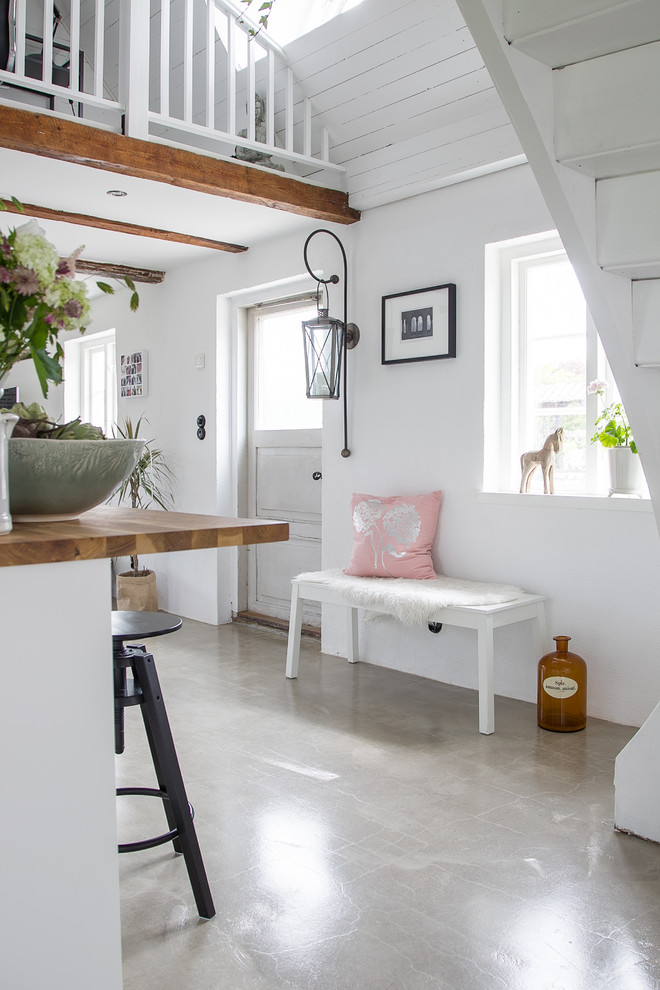 Kleines Landhaus Foyer mit weißer Wandfarbe, Betonboden und grauem Boden in Malmö
