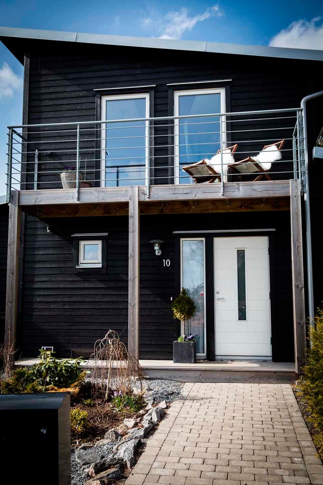 Große Skandinavische Haustür mit schwarzer Wandfarbe, Betonboden, Einzeltür und weißer Haustür in Göteborg