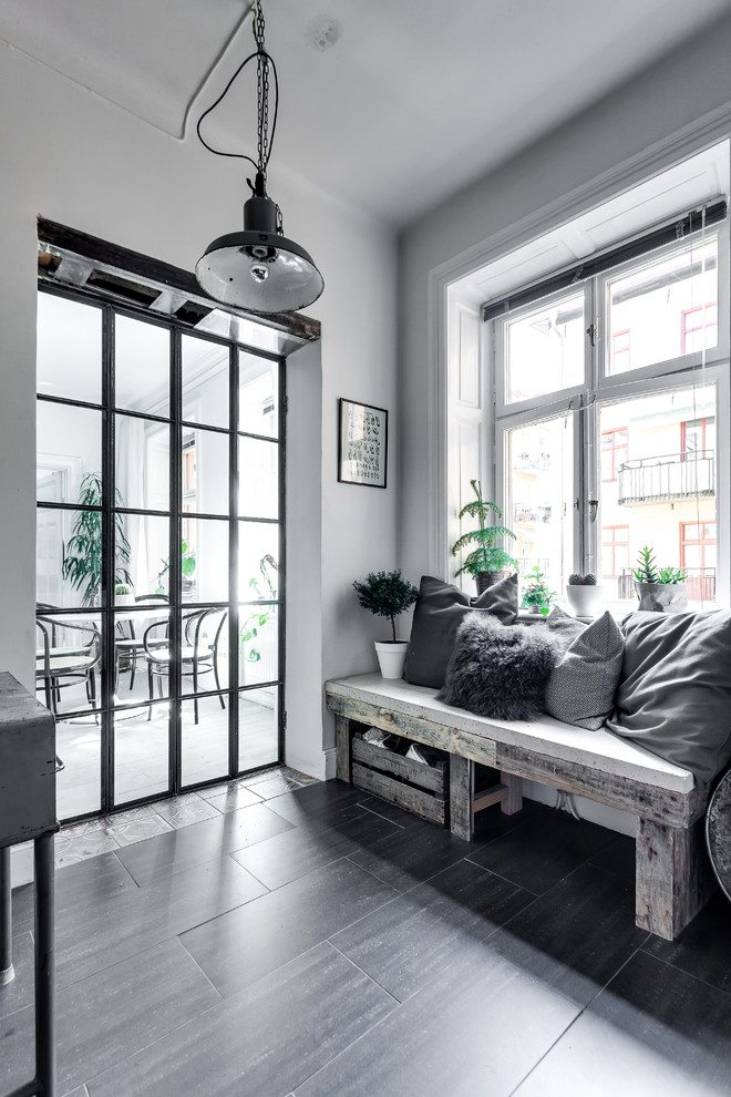 Стильный дизайн: фойе среднего размера в скандинавском стиле с белыми стенами, темным паркетным полом и одностворчатой входной дверью - последний тренд
