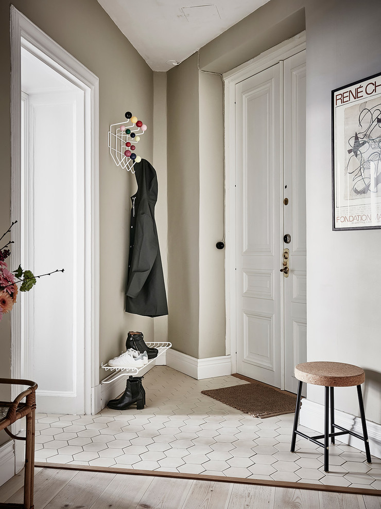 Foto på en liten skandinavisk entré, med beige väggar och vitt golv
