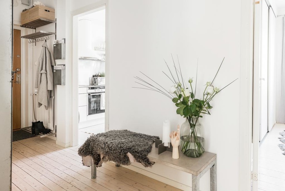 Photo of a scandi entrance in Gothenburg with white walls and light hardwood flooring.