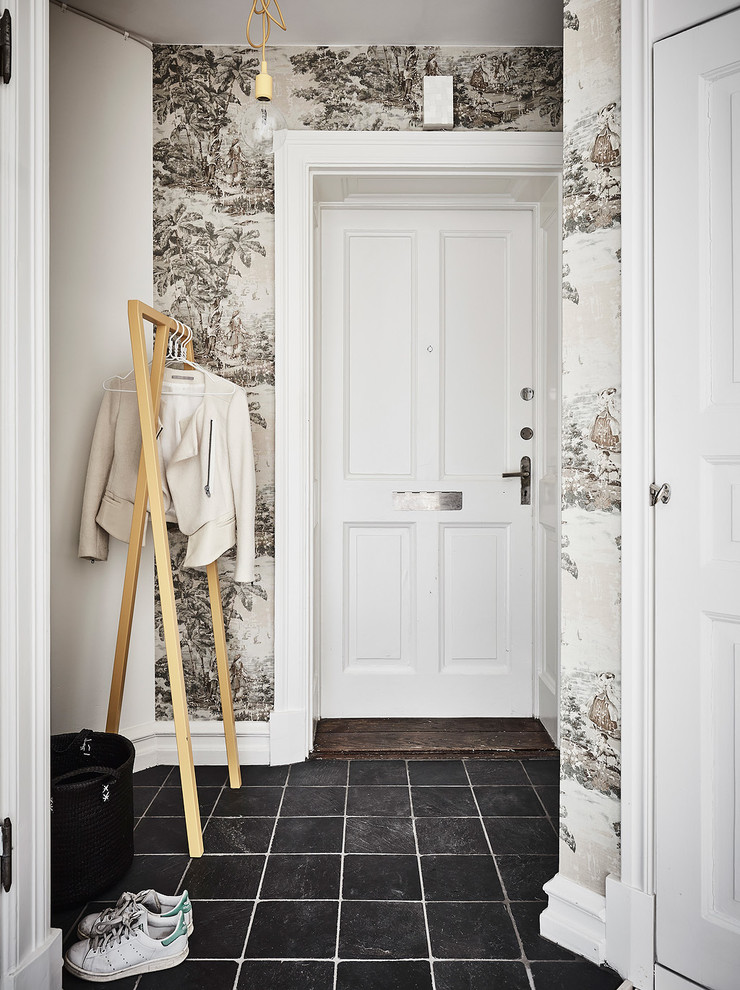 ヨーテボリにあるお手頃価格の北欧スタイルのおしゃれな玄関 (白い壁、グレーの床) の写真