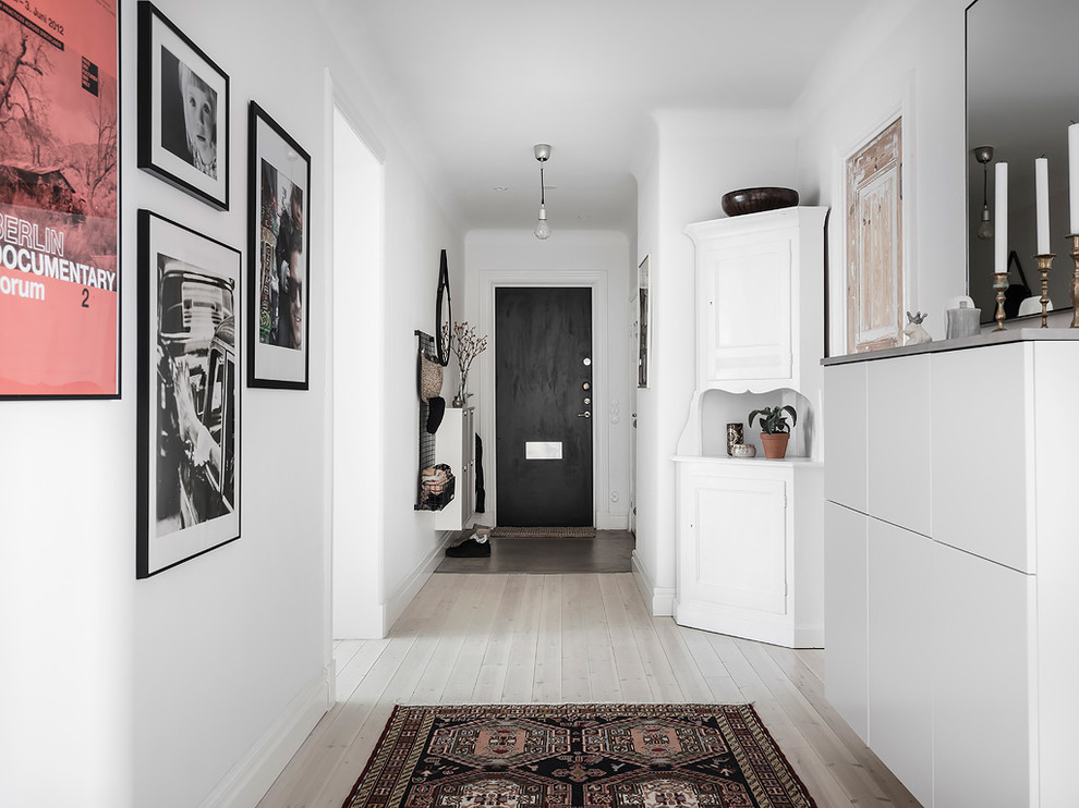 Idee per un ingresso o corridoio scandinavo di medie dimensioni con pareti bianche, parquet chiaro e pavimento beige