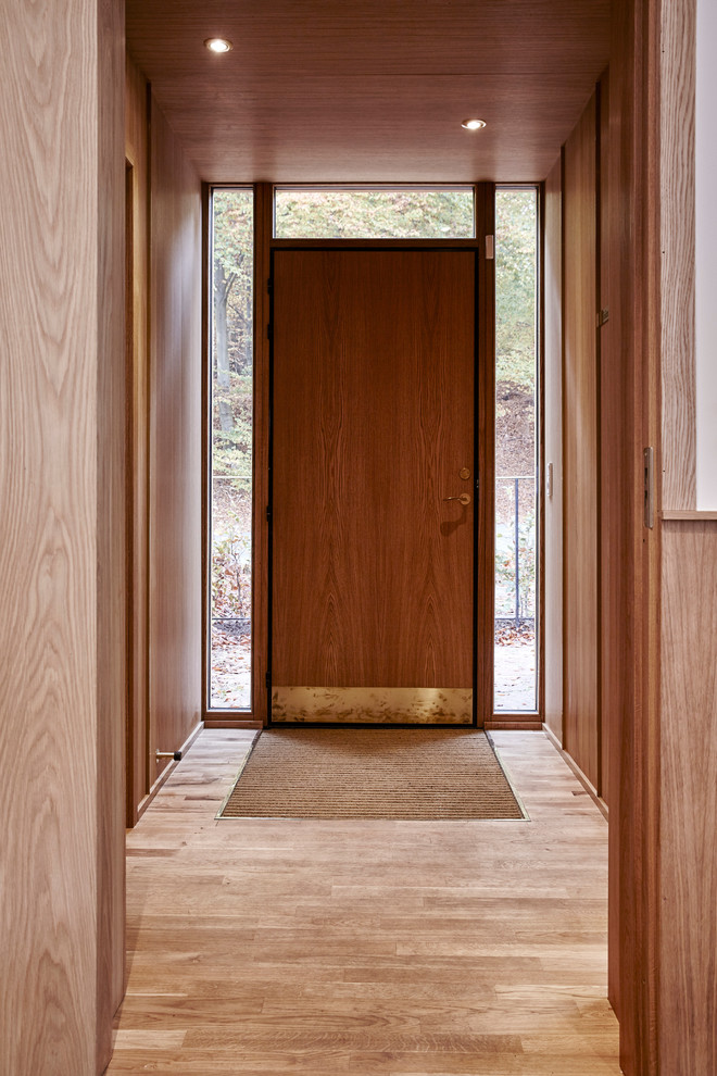 Idee per una porta d'ingresso scandinava di medie dimensioni con pareti marroni, pavimento in legno massello medio, una porta singola e una porta in legno bruno