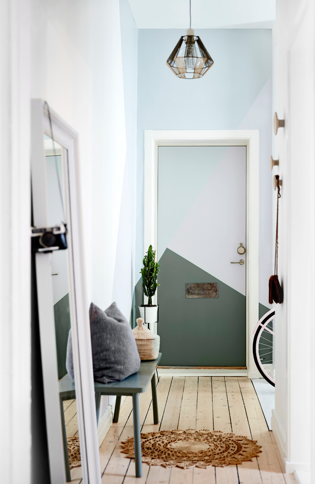 Modelo de hall escandinavo de tamaño medio con paredes multicolor, suelo de madera clara y puerta simple