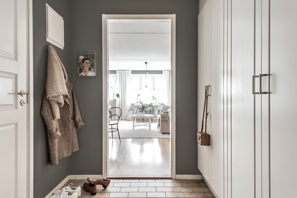 Inspiration for a mid-sized scandinavian brick floor and brown floor entryway remodel in Gothenburg with gray walls and a white front door