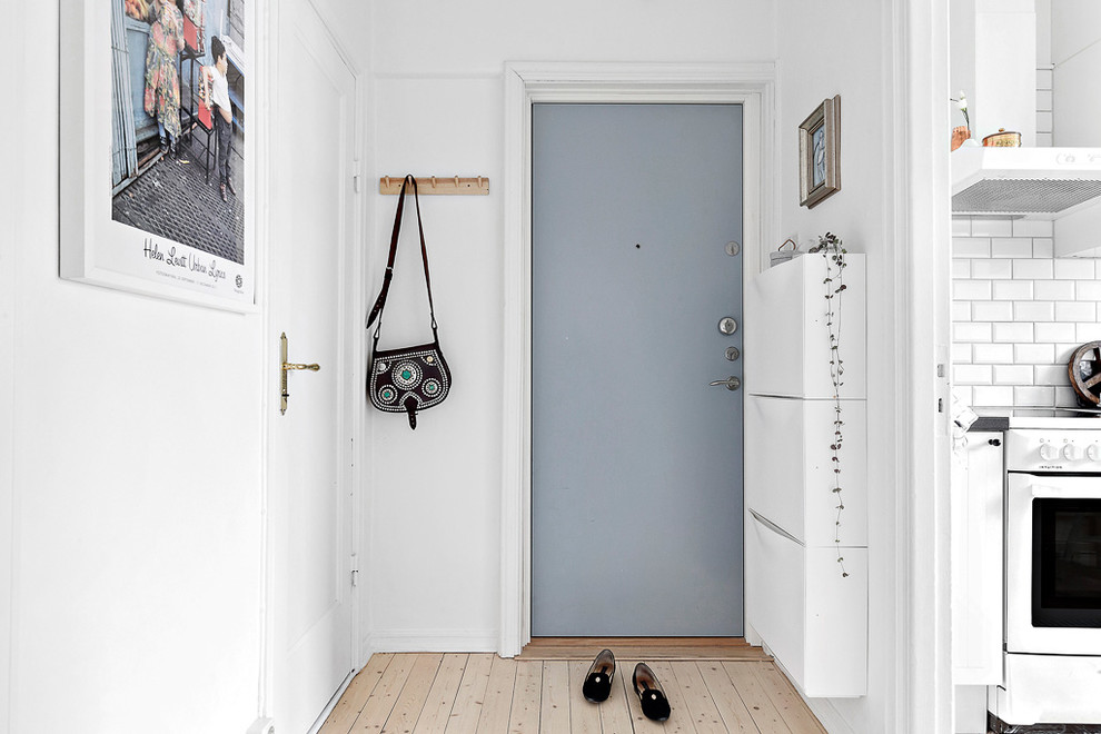 Foto på en skandinavisk entré, med en enkeldörr och en blå dörr
