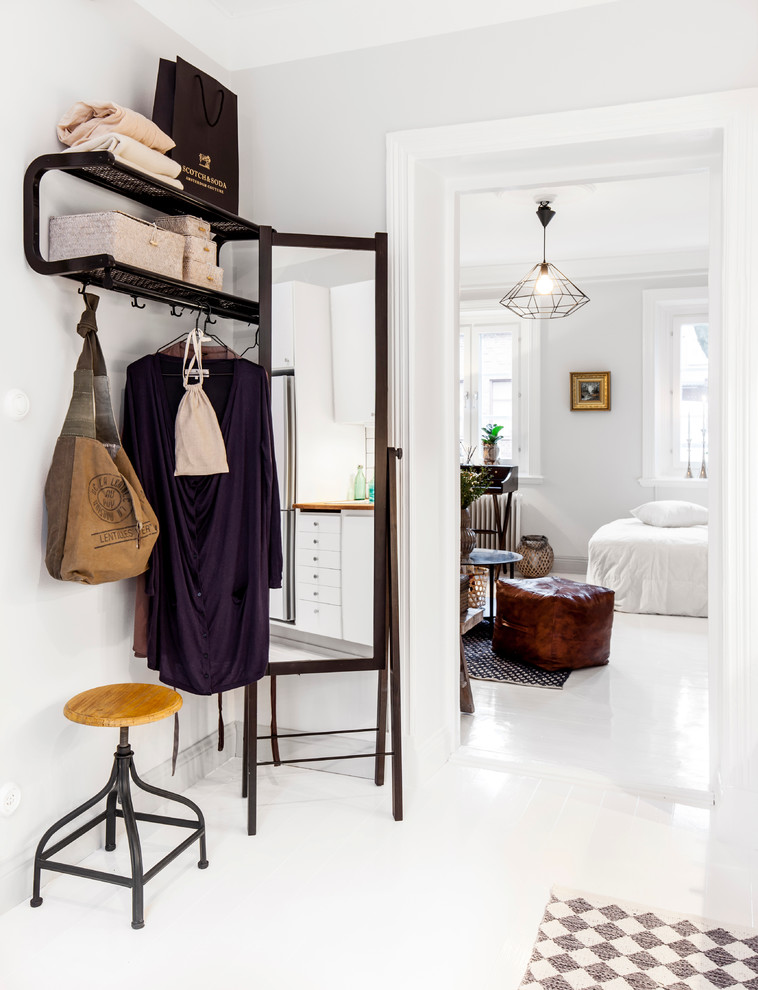 Mid-sized danish painted wood floor and white floor entryway photo in Gothenburg with white walls